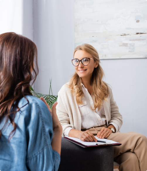 2 Women sitting an talking one has a clipboard